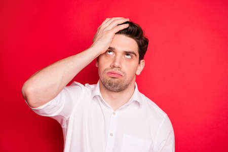 Close-up portrait of his he nice attractive dull disappointed gloomy grumpy sullen guy student exam fail failure bad result isolated over bright vivid shine red backgroundの写真素材