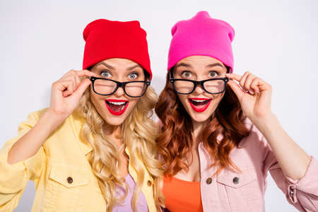 Photo of two pretty overjoyed ladies wear specs casual clothes isolated white backgroundの写真素材