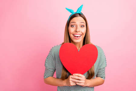 Close-up portrait of her she nice attractive lovely charming cute cheerful cheery girlish straight-haired girl holding in hands big large heart isolated over pink pastel backgroundの写真素材