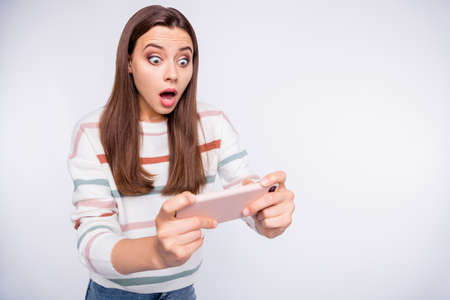 Excited lady terrified of losing telephone android game wear striped pullover isolated white...