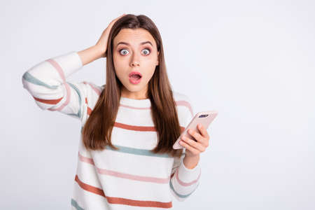 Confused lady with open mouth and telephone in hands wear striped pullover isolated white background
