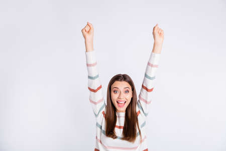 Overjoyed lady raising hands up yelling loud wear striped pullover isolated white backgroundの写真素材