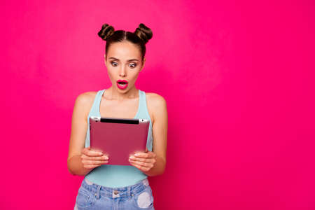 Pretty lady with e-book in hands, amazed by prices internet shop wear casual outfit isolated bright pink backgroundの写真素材
