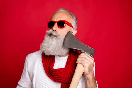 Close-up portrait of his he nice attractive handsome content virile masculine gray-haired man macho in pullover sweater pretending shaving razor ax isolated on bright vivid shine red backgroundの写真素材