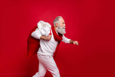 Hipster grey haired man emergency santa call wear fashion knitted clothes isolated red backgroundの写真素材