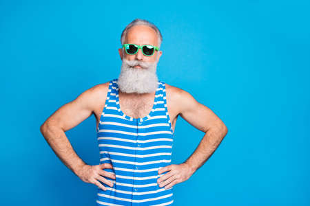 Portrait of his he nice attractive trendy funky content gray-haired man hipster tourist hands on hips isolated over bright vivid shine turquoise blue green backgroundの写真素材