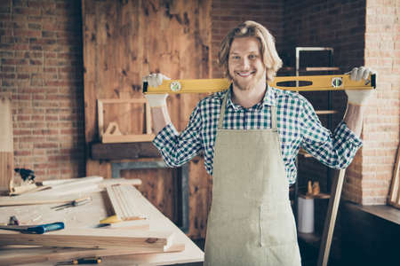 Portrait of his he nice attractive handsome, cheerful cheery guy woodworker carrying instrument ready new work day at industrial brick loft style interior indoorsの写真素材