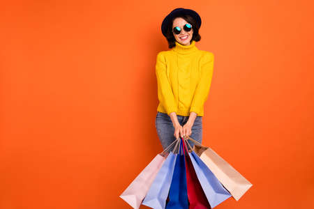 Photo of cute attractive sweet girl wearing jeans denim yellow sweater holding packages customer...