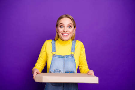 Portrait of cute lady holding pizza screaming wow omg wearing yellow turtleneck denim jeans overalls...