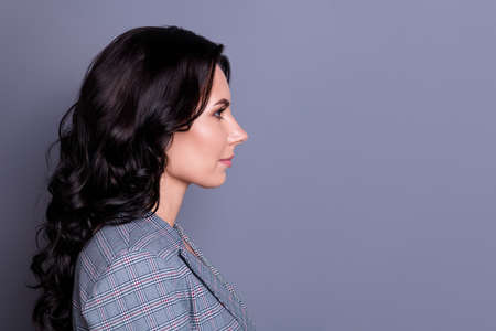 Profile side photo of gorgeous woman looking having long hairstyle wearing stylish blazer jacket isolated over grey backgroundの写真素材
