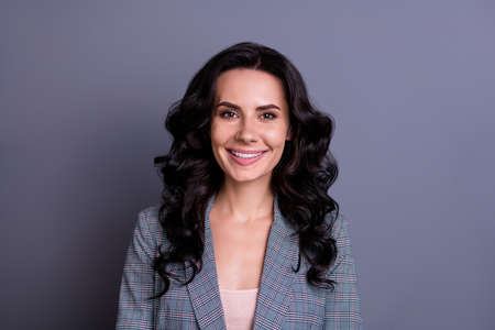 Close up photo of charming freelancer looking with toothy smile wearing suit isolated over grey backgroundの写真素材