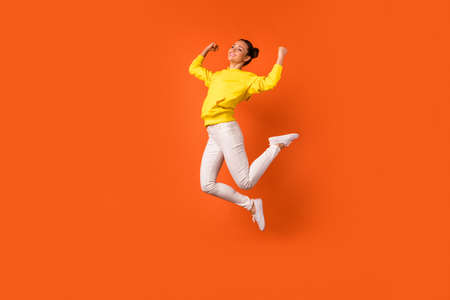 Full length photo of cheerful lovely lady raise fists smiling jumping dressed white pants trousers...