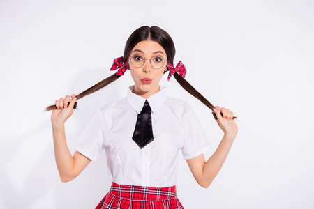 Portrait of cute nice teen teenager touch haircut dressed black white tie skirt, checkered plaid isolated lips pouted plump grey backgroundの写真素材