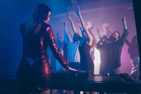 Rear back behind view of gorgeous deejay lady playing music for diverse positive cheerful cheery...