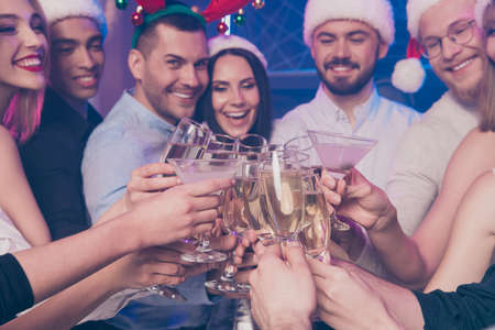 Portrait of nice-looking attractive glamorous cheerful cheery positive girls and guys having fun clinking wineglass December winter custom tradition in luxury place nightclub lights indoorsの写真素材