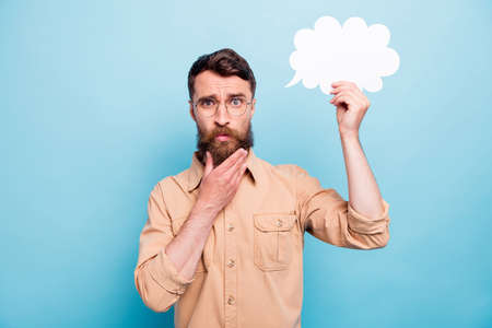 Portrait of minded man in eyewear eyeglasses holding paper card bubble touching his chin wearing...
