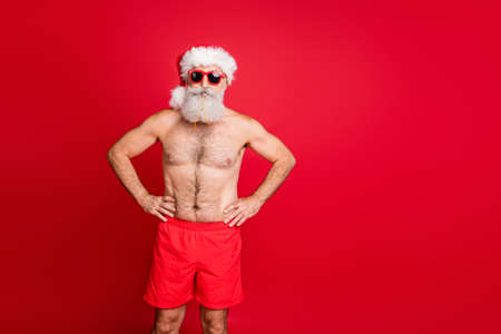 Portrait of his he nice attractive handsome funky content sporty muscular beadred gray-haired man hands on hips trip tour international tourism isolated over bright vivid shine red backgroundの写真素材