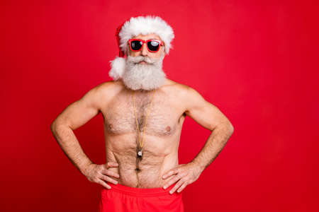Portrait of his he nice attractive handsome content sporty muscular bearded virile gray-haired macho hands on hips spa resort trip rescue save isolated on bright vivid shine red backgroundの写真素材