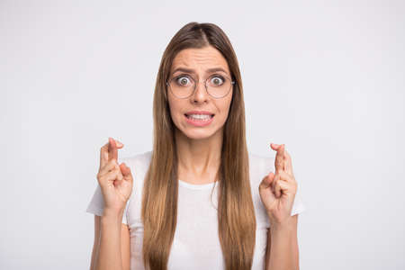 Photo of lady holding fingers crossed before final examination wear specs and casual t-shirt...