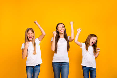 Photo of three different age ladies celebrating best win wear casual white t-shirts isolated yellow...