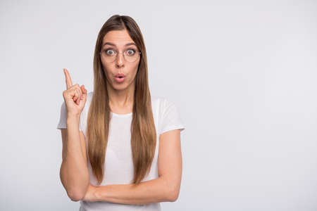 Photo of pretty lady nave awesome idea hold index finger raised wear specs and t-shirt isolated...