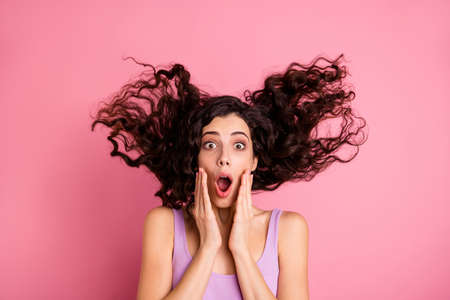 Photo of terrified frightened girl having noticed something frightful and unexpected while isolated with pink backgroundの写真素材