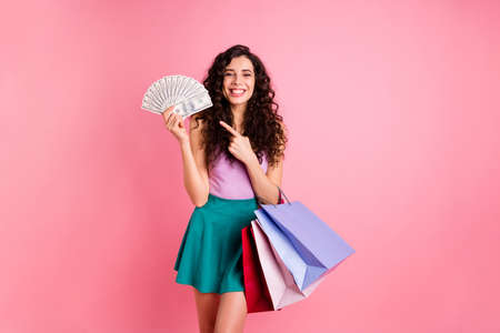 Photo of pretty trendy nice cute sweet girlfriend wearing green feminine girlish skirt pointing at money she earned while isolated with pin backgroundの写真素材