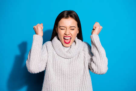 Photo of pretty lady ecstatic by amazing news wear knitted pullover isolated blue backgroundの写真素材