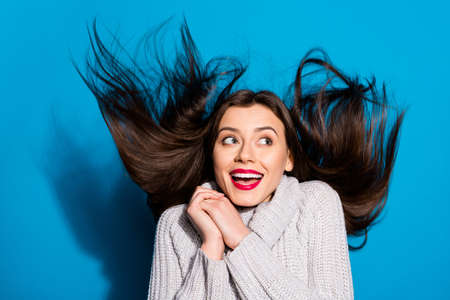 Overjoyed by warm breeze lady carefree mood wear knitted pullover, isolated blue backgroundの写真素材
