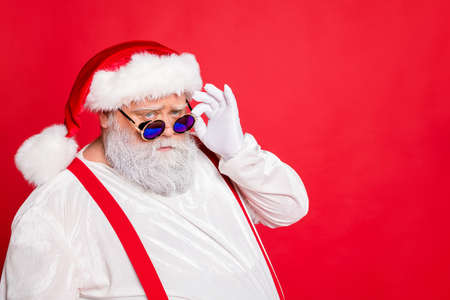 Close up photo of minded style stylish trendy fat overweight funny funky santa claus see look naughty kids with frowning face isolated over red backgroundの写真素材