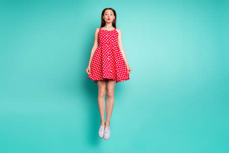 Full length photo of pretty girl jumping with her lisp pouted plump wearing polka dot skirt dress...