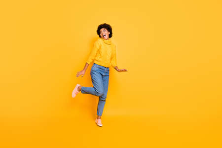 Full length body size photo of cheerful positive sweet cute nice girlfriend, resting relaxing dancing running for sales wearing sweater jeans denim isolated over vibrant color backgroundの写真素材