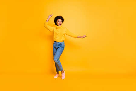 Full length body size photo of cheerful nice cute girlfriend hanging out at party, dancing wearing jeans denim sweater footwear isolated vivid color backgroundの写真素材