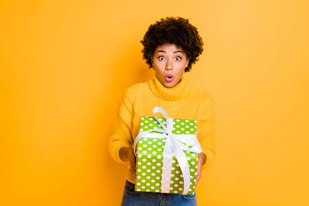 Photo of pretty cute funny black girlfriend scared with something holding gift box in her hands...