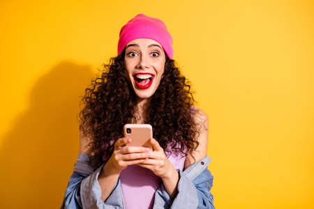 Photo of amazing curly lady holding telephone in hands checking feednews wear casual cool clothes...