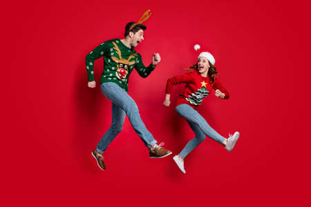 Full body photo of excited jumping couple rushing for x-mas discounts wear ugly ornament jumpers...