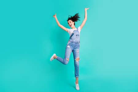 Full length body size photo of charming cute cheerful positive girlfriend rejoicing with victory of something while running isolated with turquoise bright color backgroundの写真素材