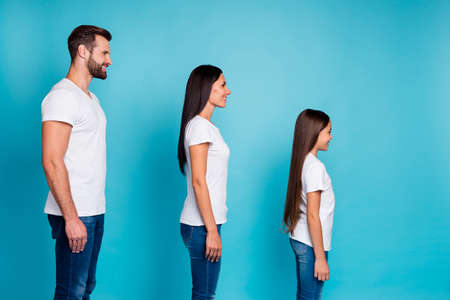 Profile side photo of charming people standing isolated wearing white t-shirt denim jeans over blue backgroundの写真素材