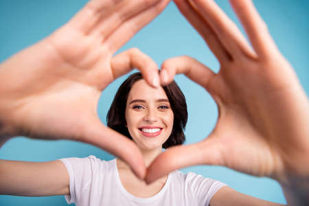 Cropped close-up portrait of her she nice attractive lovely sweet tender cheerful cheery girl showing heart symbol isolated on bright vivid shine vibrant blue turquoise color backgroundの写真素材