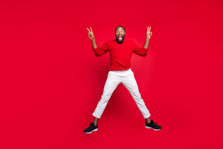 Full body photo of excited guy student jumping making v-signs wearing sweater pants trousers...