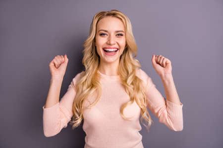 Close-up portrait of her she nice attractive lovely dreamy winsome girlish cheerful cheery positive wavy-haired girl fan holding fists isolated over gray violet purple pastel color backgroundの写真素材