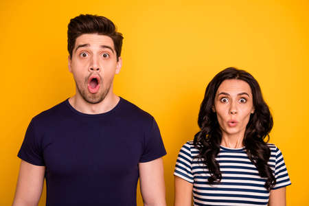 Close-up portrait of his he her she nice attractive lovely funny terrified people, married spouses showing stupor expression pout lips isolated over bright vivid shine yellow backgroundの写真素材