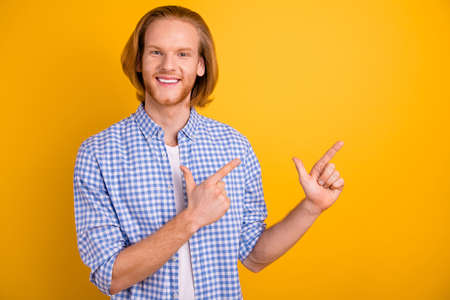 Photo of ginger foxy red headed millennial guy pointing at empty space smiling toothily beaming...