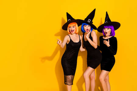 Photo of three astonished wondered crazy emotional in caps, friends watching new skills of levitation sending magic powers to ordinary crowd isolated bright color backgroundの写真素材