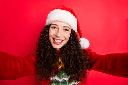 Self-portrait of her she nice attractive lovely charming winsome cheerful cheery wavy-haired Santa girl North Pole traveler isolated on bright vivid shine vibrant red color backgroundの写真素材