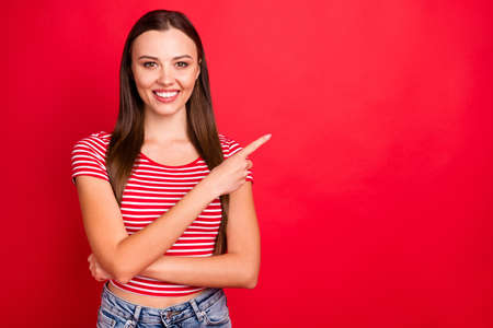 Photo of cheerful cute charming gorgeous woman pointing at best decision to show it to you while isolated with red backgroundの写真素材