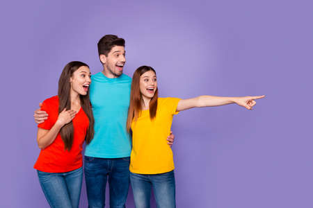 Portrait of nice attractive lovely cheerful cheery glad guys wearing colorful t-shirts denim pointing far away waiting expecting isolated over violet lilac backgroundの写真素材
