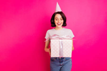 Photo of cheerful cute charming nice fascinating girlfriend wearing jeans denim being surprised with unexpected gift while isolated over fuchsia vivid color backgroundの写真素材