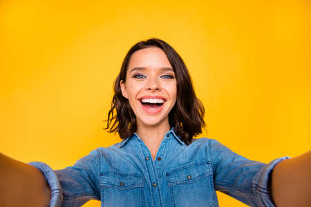 Close up photo of funny funky youth make selfie on travel enjoy free time on spring vacation wear trendy t-shirt isolated over yellow color backgroundの写真素材