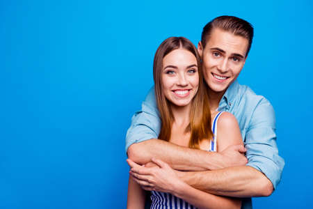 Close-up portrait of his he her she two nice attractive sweet gentle lovely cheerful people embracing isolated over bright vivid shine vibrant blue turquoise color backgroundの写真素材